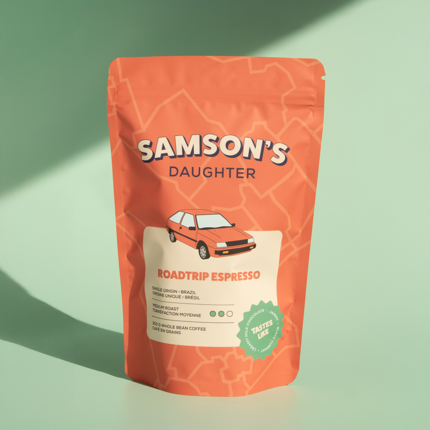 A bag of whole bean Roadtrip Espresso with a green background in hard light.