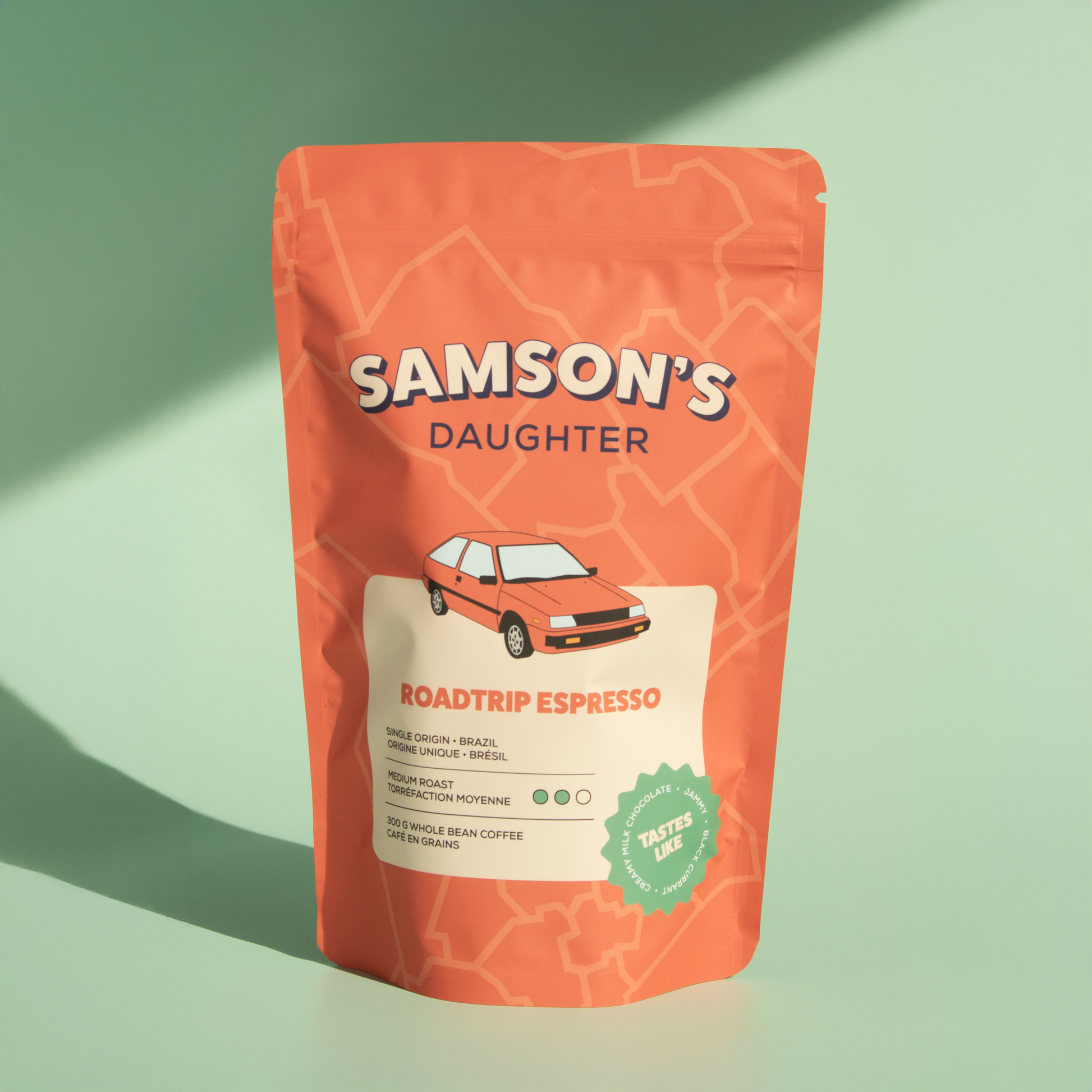 A bag of whole bean Roadtrip Espresso with a green background in hard light.